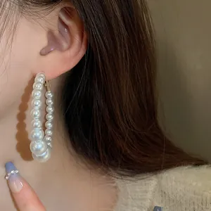 Elegant pearl hoop earrings with graduated beads in vintage French style on model ear