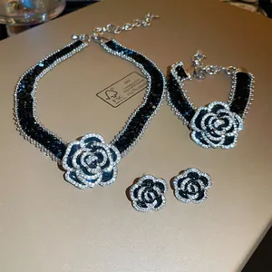 Vue détaillée de la parure de bijoux camélia noir de luxe français avec des éclats de zircon.