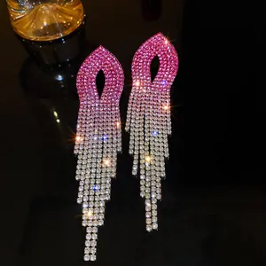 Close-up view of pink gradient rhinestone tassel earrings featuring long dangling crystal strands