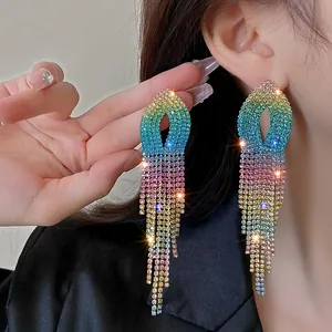 Close-up of vibrant rainbow rhinestone tassel earrings worn on ear for a stylish feminine look