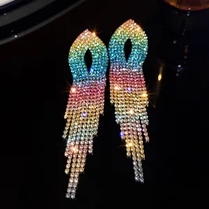 Close-up detail of elegant rainbow gradient rhinestone tassel earrings on dark background