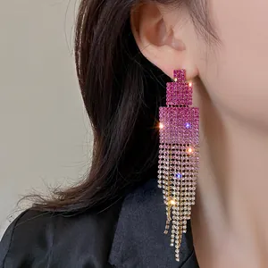 Close-up of elegant magenta gradient rhinestone fringe earrings worn by a model