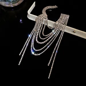 Elegant multi-layer tassel brooch featuring sparkling rhinestones on a black background.