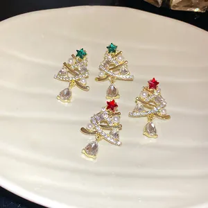 Primo piano di orecchini a forma di albero di Natale con perline e cristalli pendenti