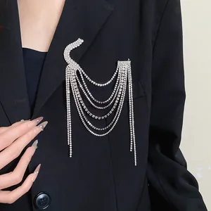 Detailed view of an elegant silver multi-layer rhinestone tassel brooch on a black blazer