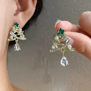 Dettaglio di orecchini a forma di albero di Natale con strass e perle eleganti.
