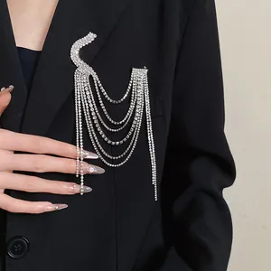 Detailed view of a silver rhinestone multi-layer tassel brooch on a black blazer jacket