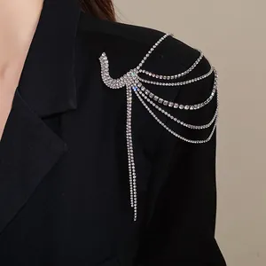 Close-up detail of an elegant rhinestone multi-layer fringe brooch worn on a black blazer.