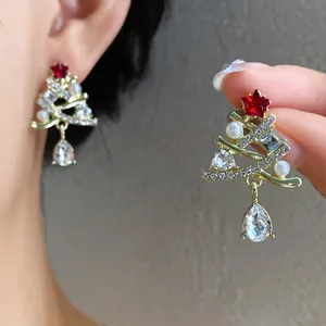 Primo piano dettagliato di orecchini a lobo a forma di albero di Natale con perle e cristalli
