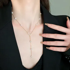 Close-up of elegant gold heart necklace with baroque pearls worn on model's neck detail