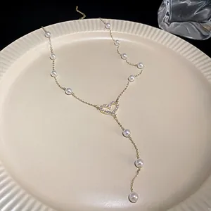 Close-up of a gold-plated French baroque pearl heart pendant necklace on a plate