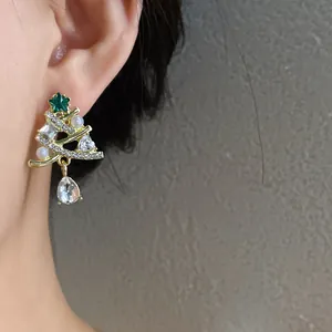 Dettaglio di un orecchino ad albero di Natale con perle e strass scintillanti all'orecchio