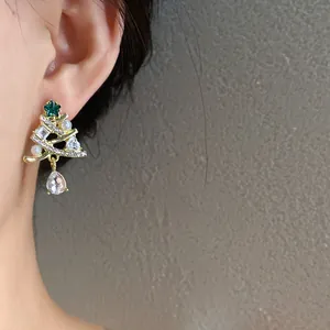 Primo piano di un orecchino ad albero di Natale con perle e cristalli scintillanti all'orecchio