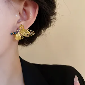 Detailansicht von goldenen Schmetterlingsohrsteckern im Vintage-Stil mit Kristallen