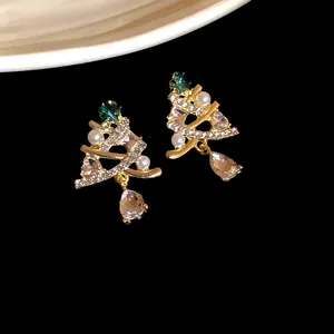 Dettaglio di orecchini a forma di albero di Natale con strass brillanti e perle