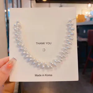 Close-up of elegant French Baroque pearl necklace displayed on a white thank-you card