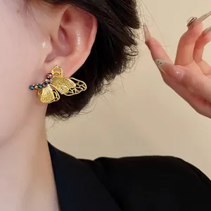 Nahaufnahme eines goldenen Schmetterlings-Ohrrings im Vintage-Stil mit Strass