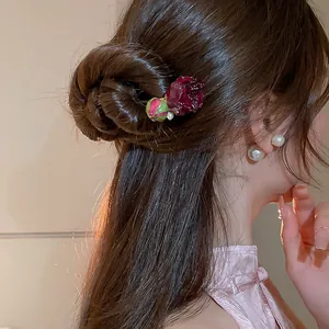 Elegante bastoncino per capelli con rosa essiccata e perle in uno chignon in stile vintage