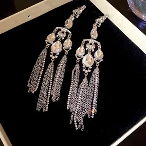 Exaggerated silver tassel earrings with teardrop crystals and sparkling rhinestones