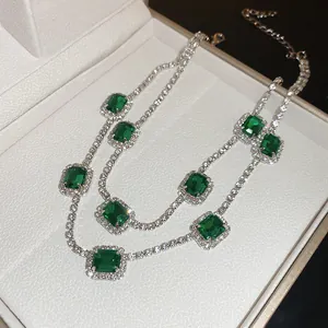 Elegant silver-tone necklace with emerald-cut green zirconia and sparkling halo diamonds