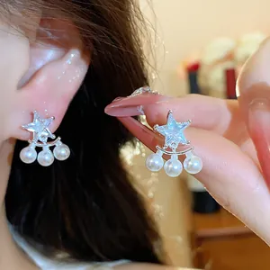 Detailed view of silver star stud earrings featuring sparkling zircon and elegant pearls.