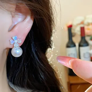 Detailed close-up view of elegant zircon flower pearl stud earrings worn on a female ear