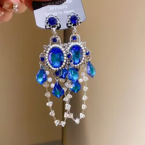 Close-up detail of vintage palace style earrings featuring blue zircons and elegant tassels