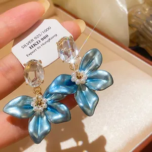 Macro view of retro court style blue flower earrings with clear zircon and pearls