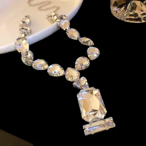 Close-up detail of a luxurious water-drop and rectangular crystal pendant necklace