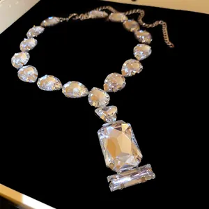 Close-up of water drop and rectangle crystal pendant necklace for evening dress