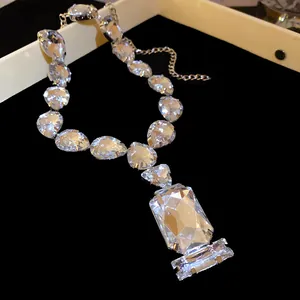 Close-up of elegant waterdrop and square rhinestone pendant necklace for formal dresses