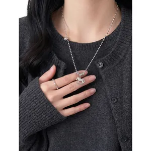 Elegant silver-toned ball chain necklace with zircon-encrusted rocking horse and flower pendant