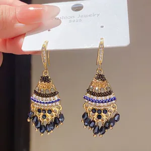 Close-up of vintage palace style tassel earrings with zircon and geometric details