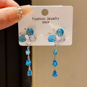 Macro view of blue butterfly tassel earrings with zircon stones and silver needle
