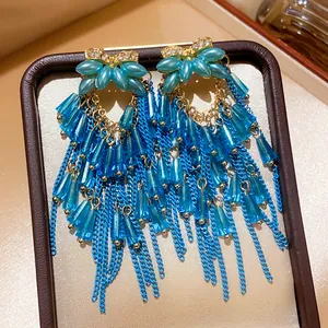 Close-up of vintage palace style blue tassel earrings with rhinestones and beads.