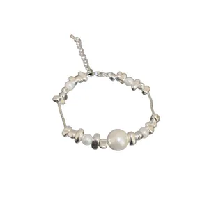 Minimalist titanium steel bracelet featuring pearls and irregular silver beads on white background