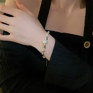 Detail shot of titanium steel bracelet with pearls and crushed silver beads on wrist.