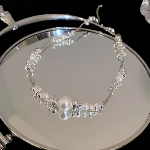 Elegant detail shot of titanium steel silver nugget and pearl bracelet reflected on a mirror surface