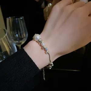 Close-up shot of a minimalist titanium steel bracelet with pearls worn on a wrist
