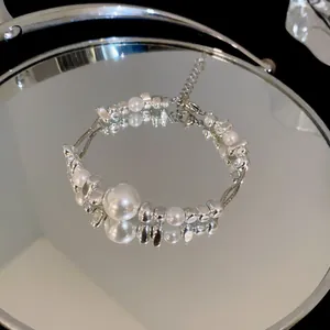 Elegant titanium steel bracelet with pearls and silver beads detail on mirror surface