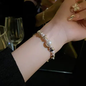 Close-up of titanium steel bracelet with pearls and silver fragments on a wrist