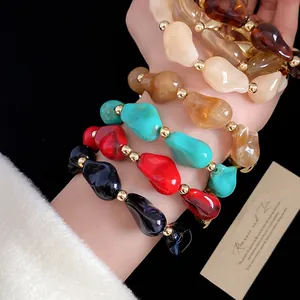 Primo piano di braccialetti colorati in perline di acrilico irregolari al polso