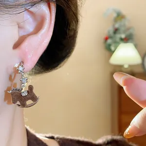 Detailed view of retro flocked rocking horse earrings with sparkling zircon flowers