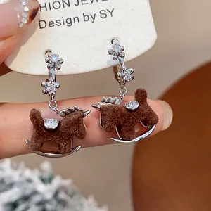 Close-up shot of retro brown flocked rocking horse earrings with sparkling zircon detailing