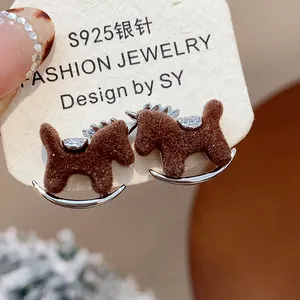Detailed view of brown flocked rocking horse stud earrings with sparkling zircons