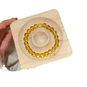 Elegant translucent yellow agate beaded bracelet displayed on a natural wooden block.