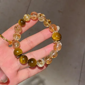 Close-up of citrine and tiger's eye beaded bracelet with gold filigree charm