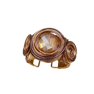 Bracciale rigido boho avvolto in filo metallico con pietra centrale in vetro ambra sfaccettato.