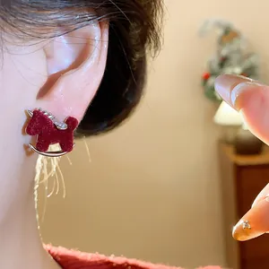 Macro view of a red flocked rocking horse stud earring with silver and zircon details