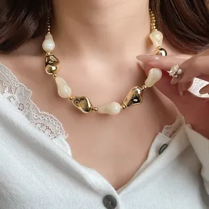 Dettaglio ravvicinato di una collana vintage con perle in acrilico e oro su una modella